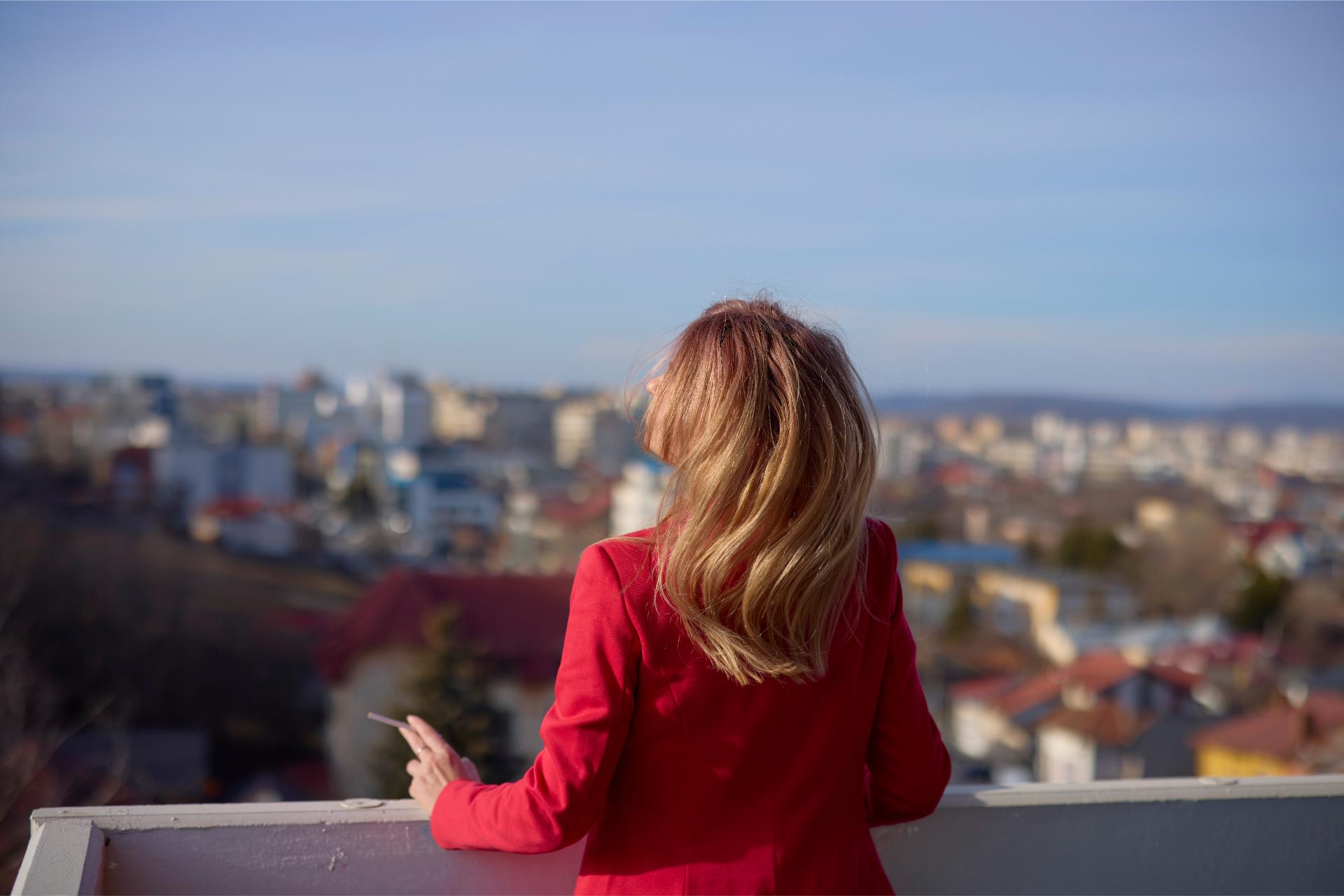 A Woman On The Balcony Smoking On A Sunny Day